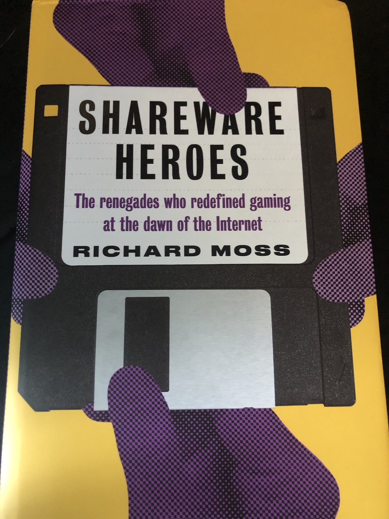 Cover of Shareware Heroes, showing a hand holding a floppy disk